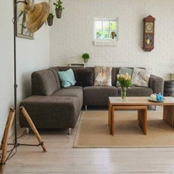 Cozy living room with a gray sectional sofa, wooden furniture, and decorative plants.